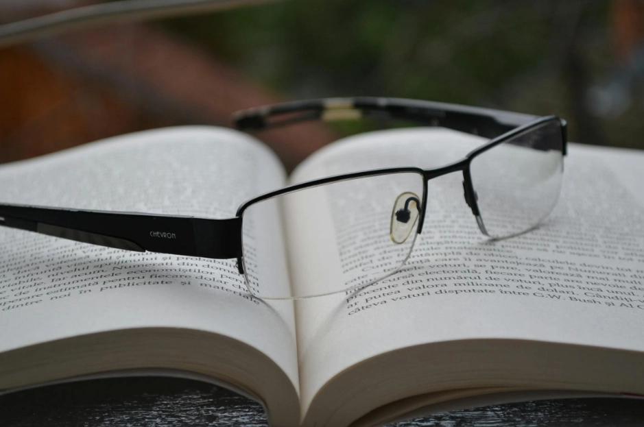Clear glasses and an open book on a black frame