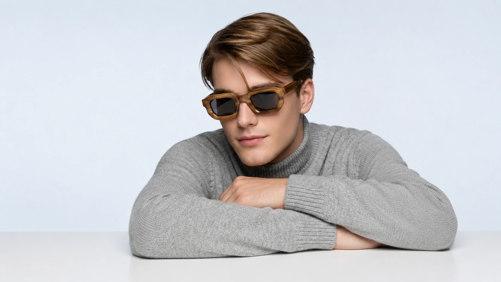 Man wearing stylish sunglasses and a gray sweater